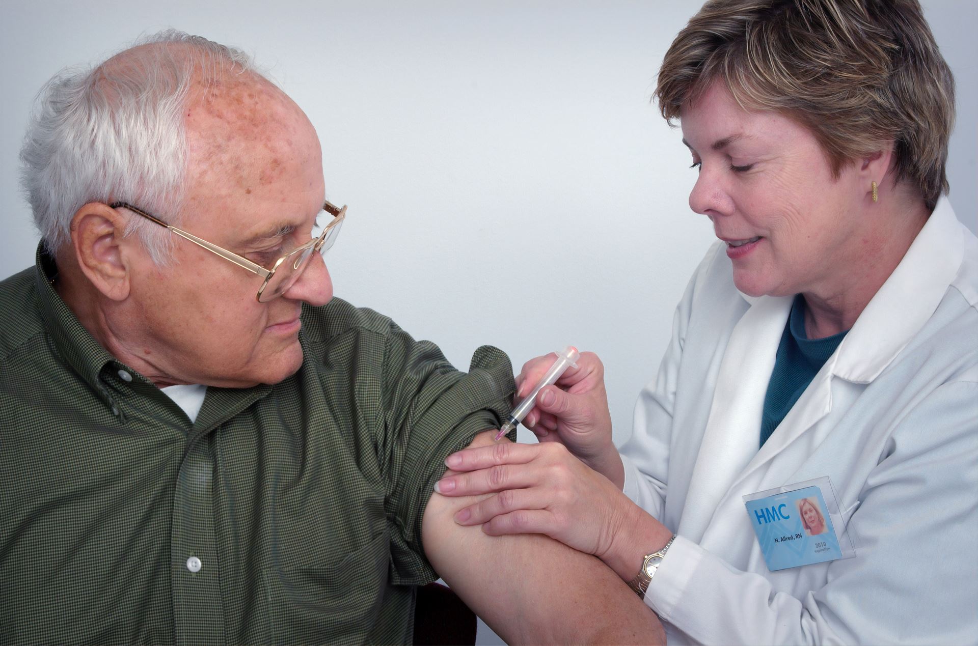 a clinician giving an older man a vaccination