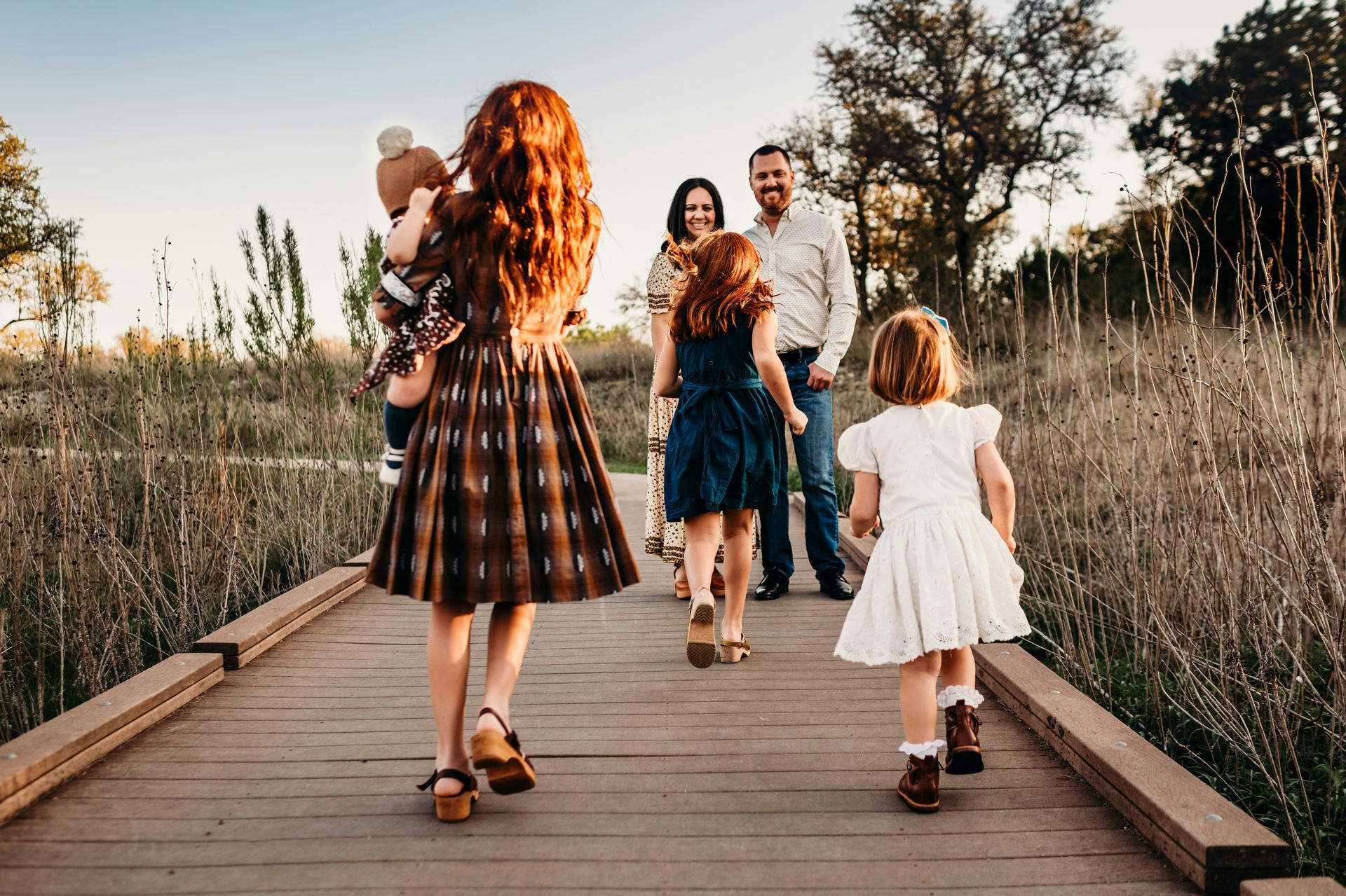 a mother and father walking with their children in a public space
